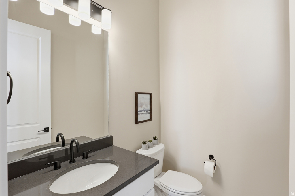 Contemporary vanity featuring an undermount sink, dark countertop, and matte black faucet fixtures
