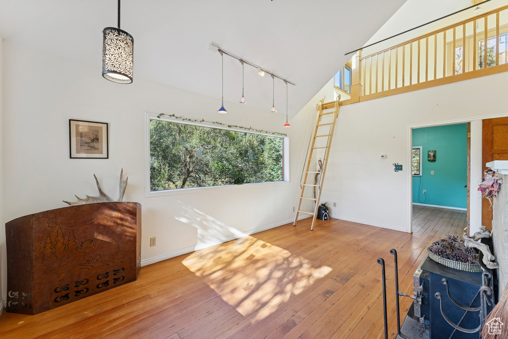 Living area featuring high vaulted ceiling, track lighting, and wood-type flooring