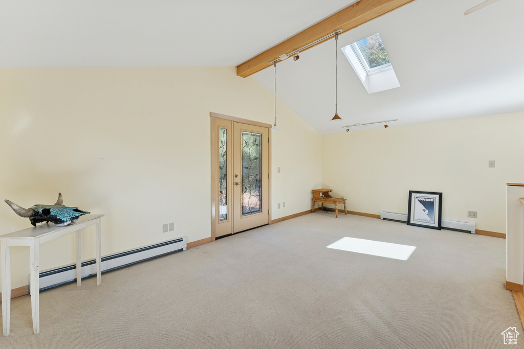 Spare room featuring track lighting, carpet flooring, a baseboard heating unit, and a skylight