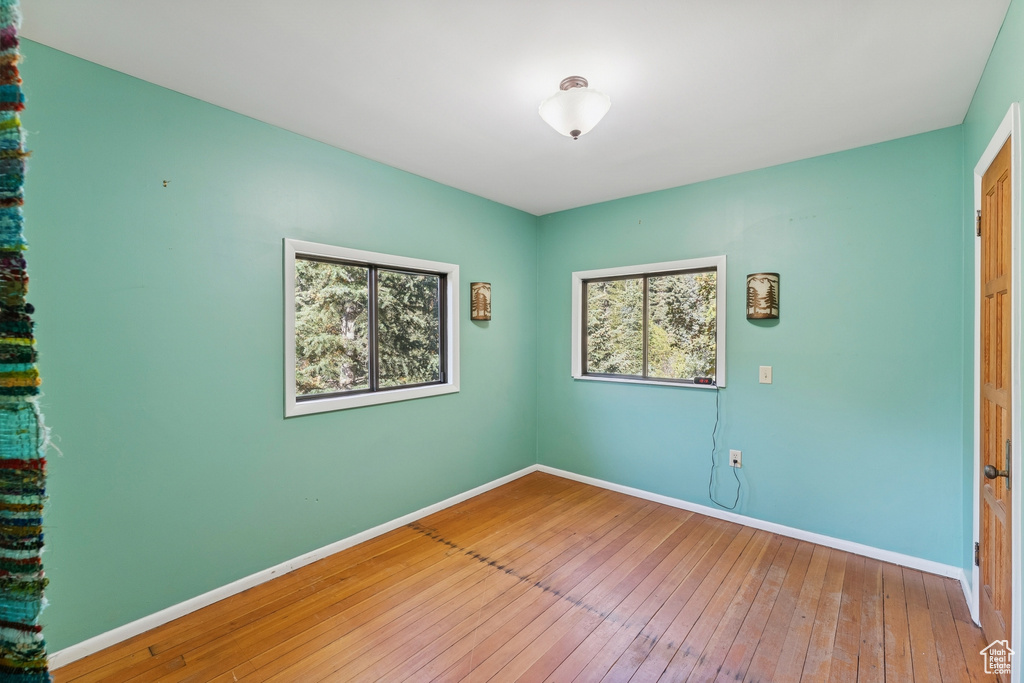 Unfurnished room with hardwood / wood-style floors and baseboards