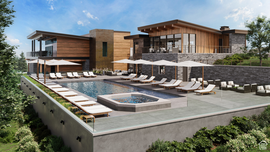 Rear view of property with a community pool, a patio area, an outdoor living space with a fire pit, and stone siding