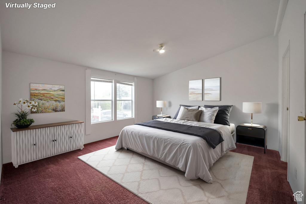 Bedroom with dark colored carpet and vaulted ceiling