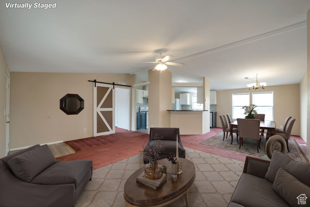 Living room featuring a barn door, carpet floors, a chandelier, vaulted ceiling, and ceiling fan