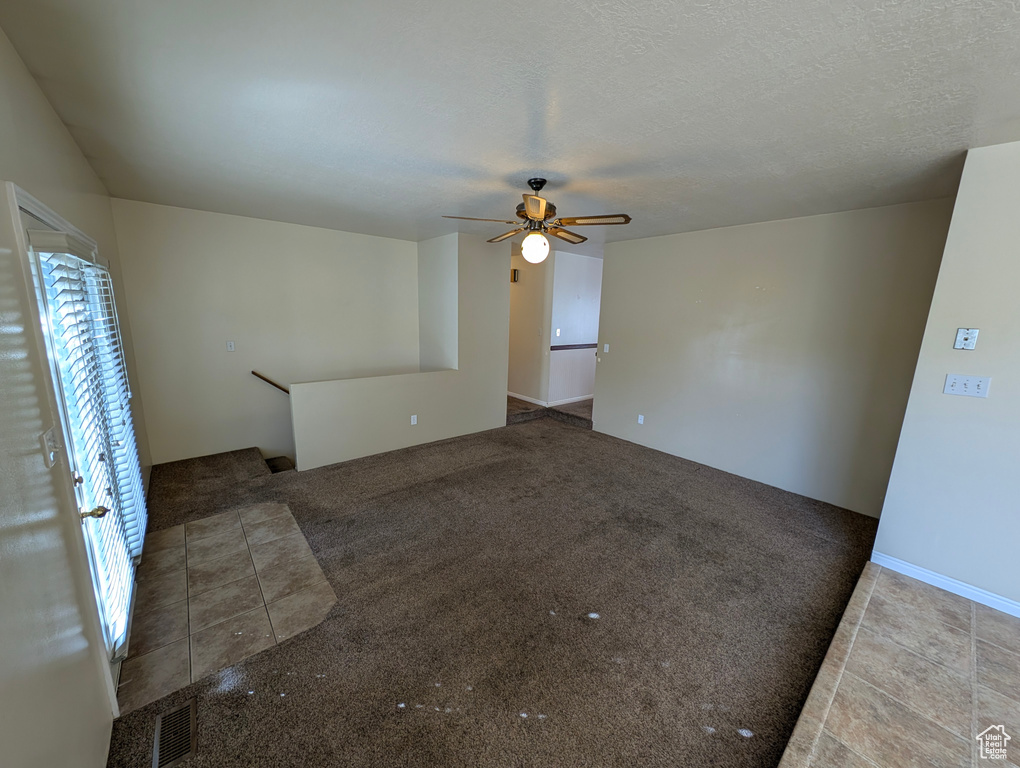 Unfurnished living room featuring light colored carpet and ceiling fan