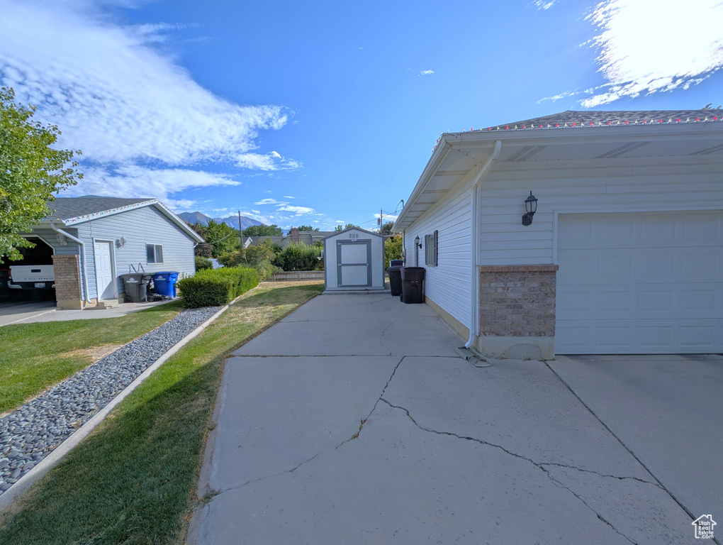 View of home's exterior with an outbuilding, brick siding, concrete driveway, and a garage