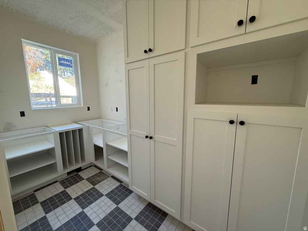 Kitchen with light tile patterned flooring and a textured ceiling
