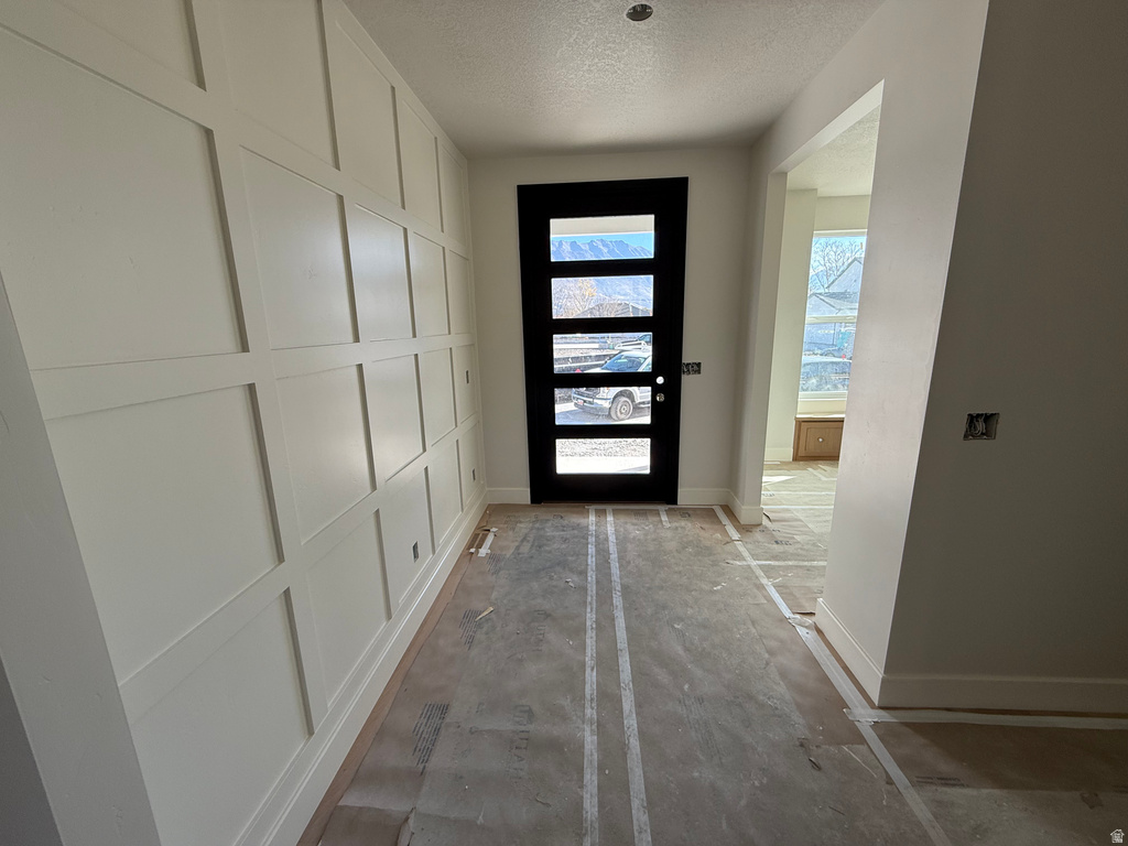 Foyer entrance featuring a textured ceiling and baseboards