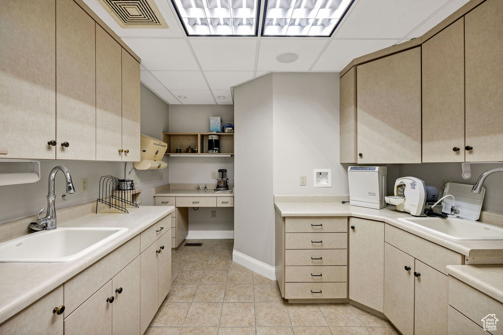 Kitchen featuring a drop ceiling, light brown cabinets, light countertops, light tile patterned floors, and open shelves