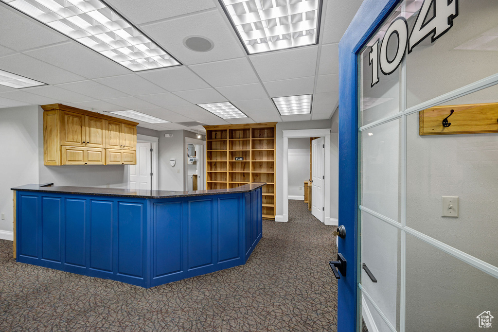 Unfurnished office with dark colored carpet and a paneled ceiling