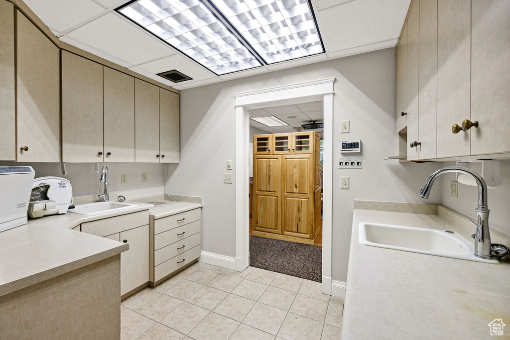 Laundry room featuring a sink and light tile patterned flooring