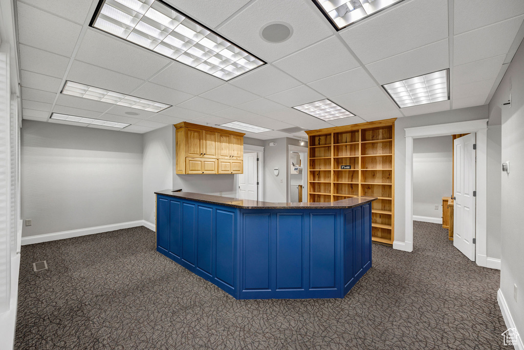 Kitchen featuring dark carpet, open shelves, a paneled ceiling, and a peninsula