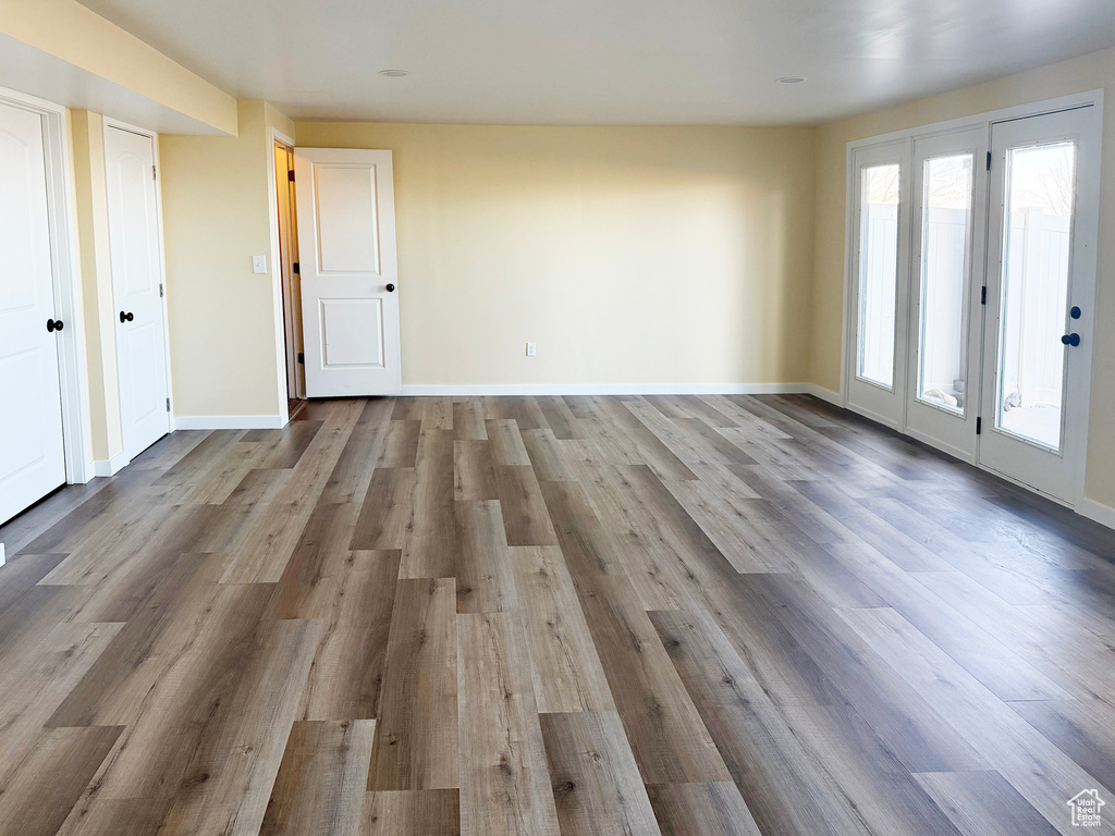 Unfurnished living room featuring baseboards and light wood-style flooring