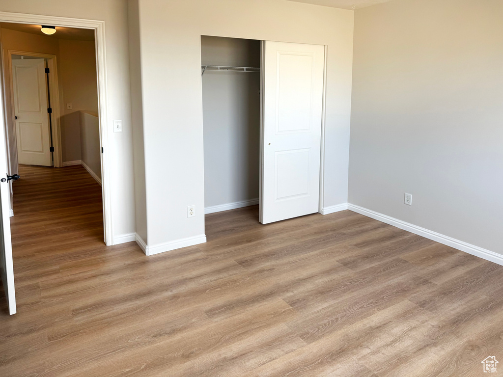Unfurnished bedroom with light wood finished floors and a closet