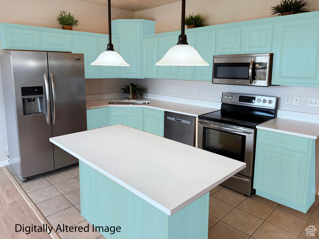 Kitchen featuring appliances with stainless steel finishes, light countertops, and a center island