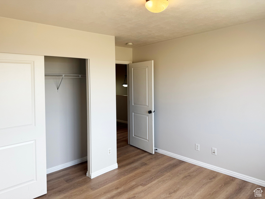 Unfurnished bedroom featuring light wood-style flooring and a closet