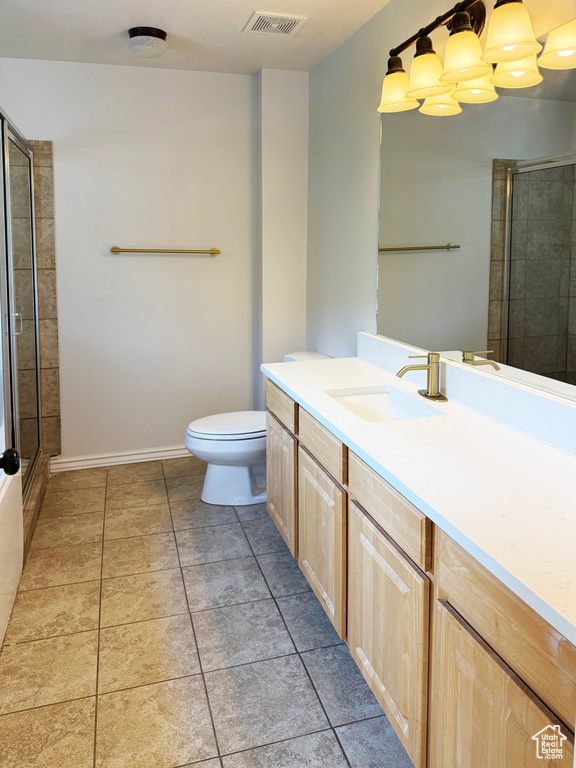 Full bath featuring vanity, a stall shower, light tile patterned floors, and a chandelier