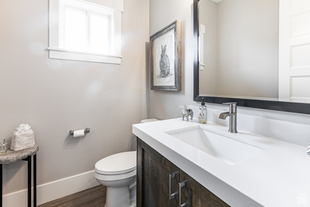 Half bath featuring vanity and dark wood finished floors