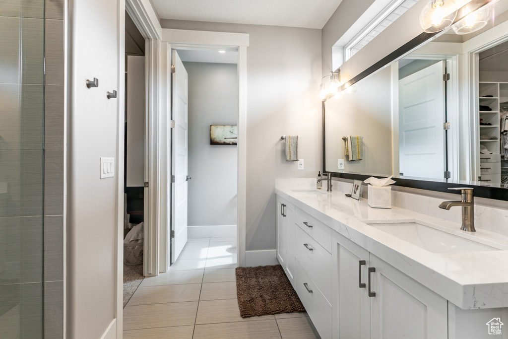 Bathroom featuring double vanity and light tile patterned floors