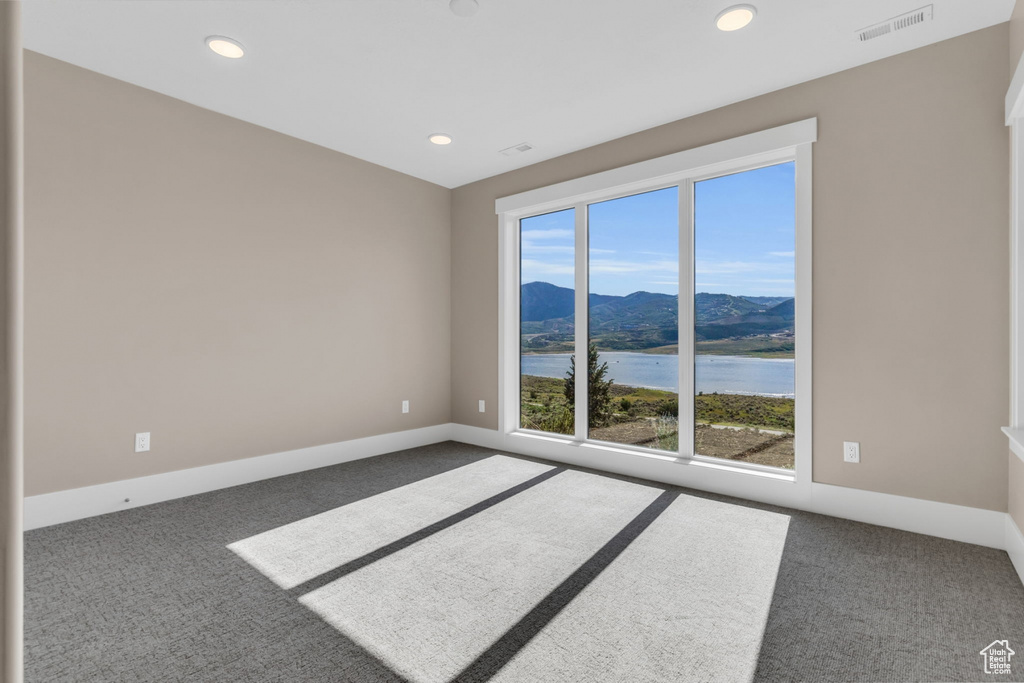 Spare room featuring a water and mountain view, carpet flooring, and recessed lighting