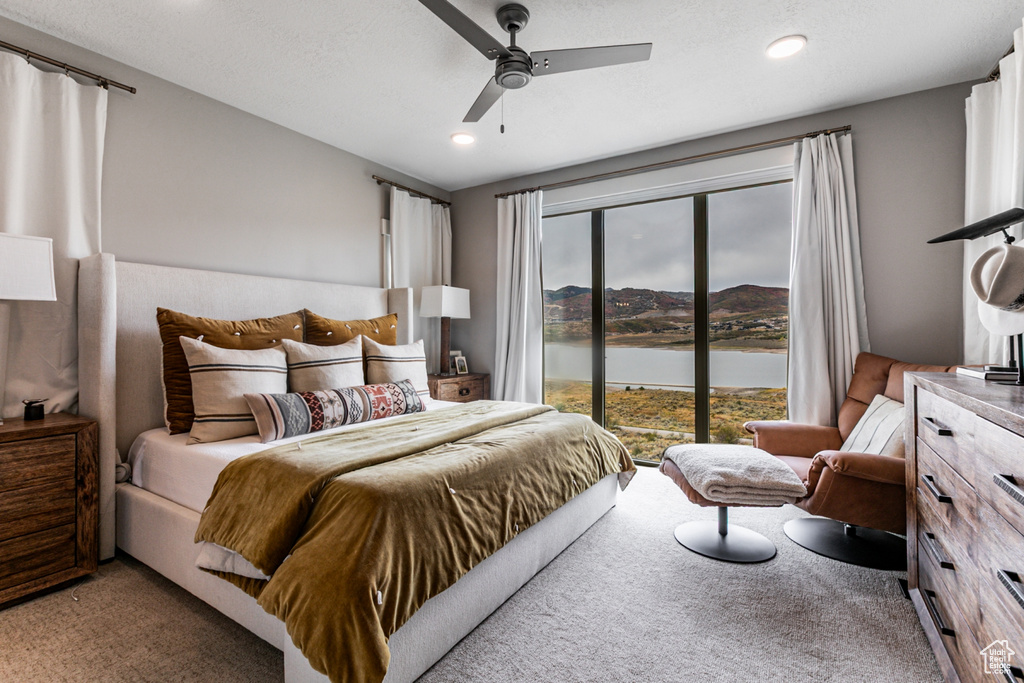 Carpeted bedroom featuring a water view, a ceiling fan, access to outside, and recessed lighting