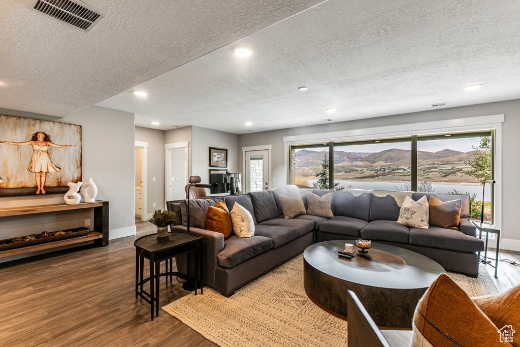 Living area with wood finished floors, a textured ceiling, recessed lighting, and a mountain view