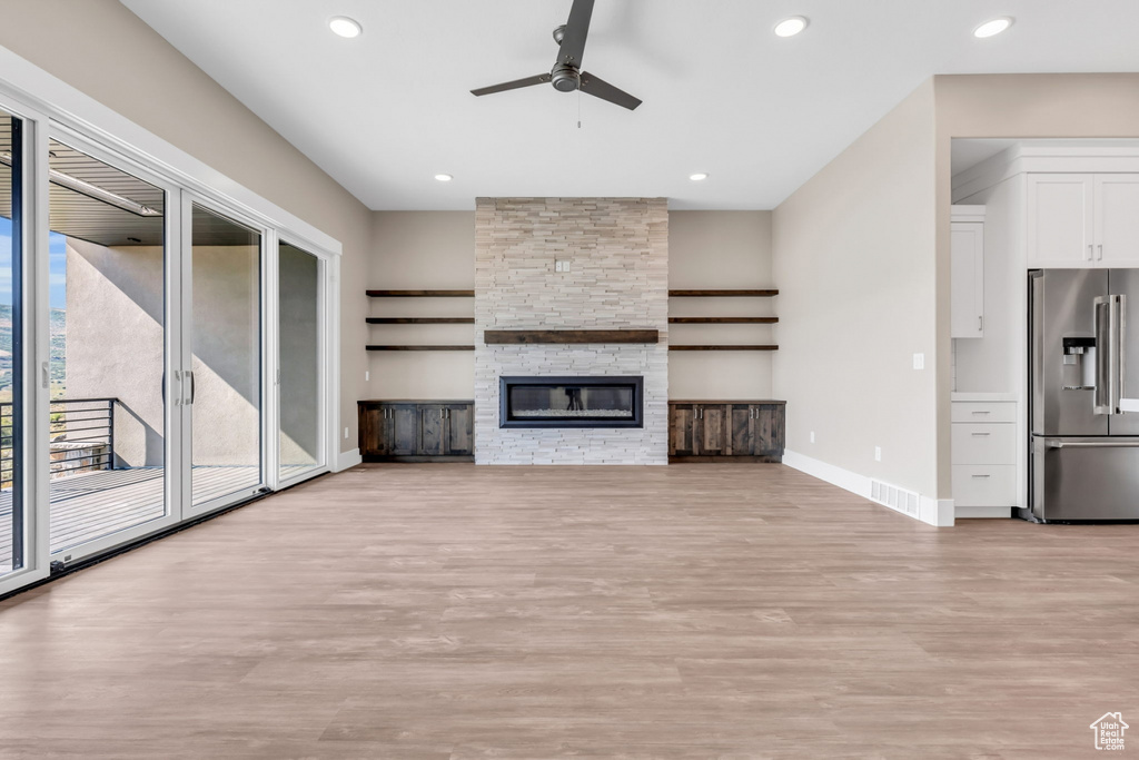 Unfurnished living room featuring light wood-type flooring, recessed lighting, ceiling fan, and a fireplace