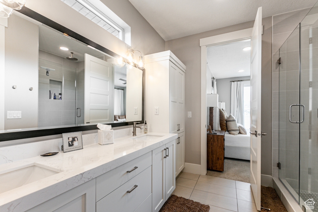 Full bathroom with connected bathroom, double vanity, light tile patterned flooring, and a stall shower