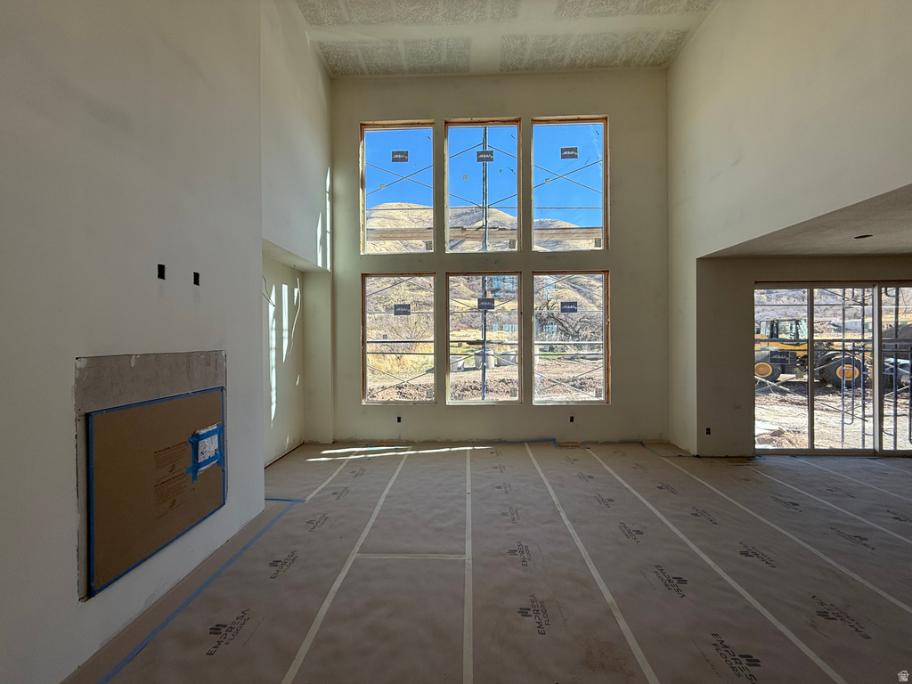 Unfurnished living room with a towering ceiling