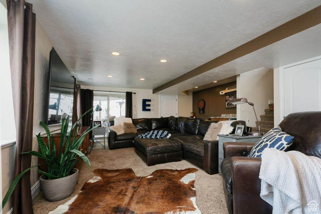 Carpeted living area with stairs, a textured ceiling, and recessed lighting