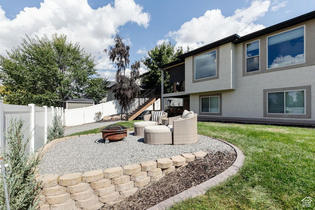 Fenced backyard featuring a fire pit, a patio, and stairway