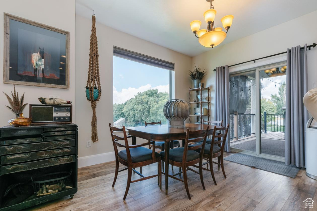 Dining room with light wood finished floors and a chandelier