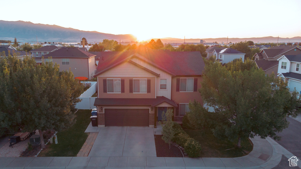 Traditional-style house with a residential view, driveway, a mountain view, and an attached garage