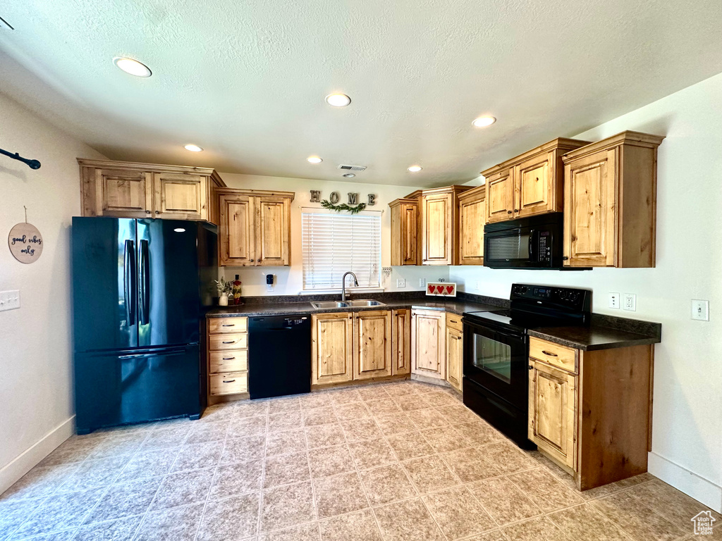Kitchen with black appliances, dark countertops, recessed lighting, and a textured ceiling