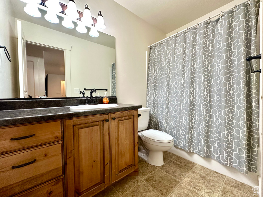 Full bath with vanity and light tile patterned floors