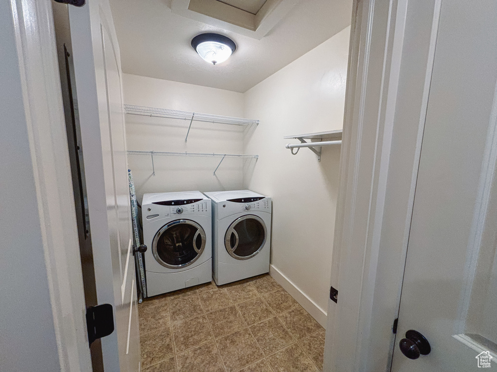 Laundry area with washing machine and clothes dryer and baseboards