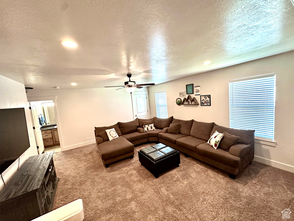 Living area featuring carpet, a textured ceiling, recessed lighting, and a ceiling fan