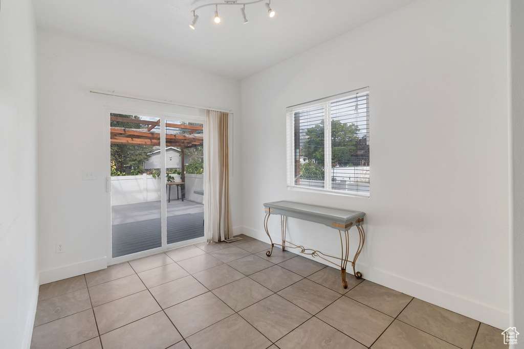 Empty room with healthy amount of natural light and light tile patterned floors
