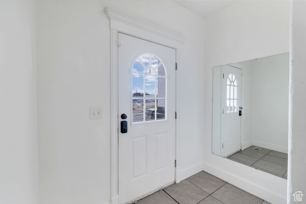 Entrance foyer featuring light tile patterned floors and baseboards