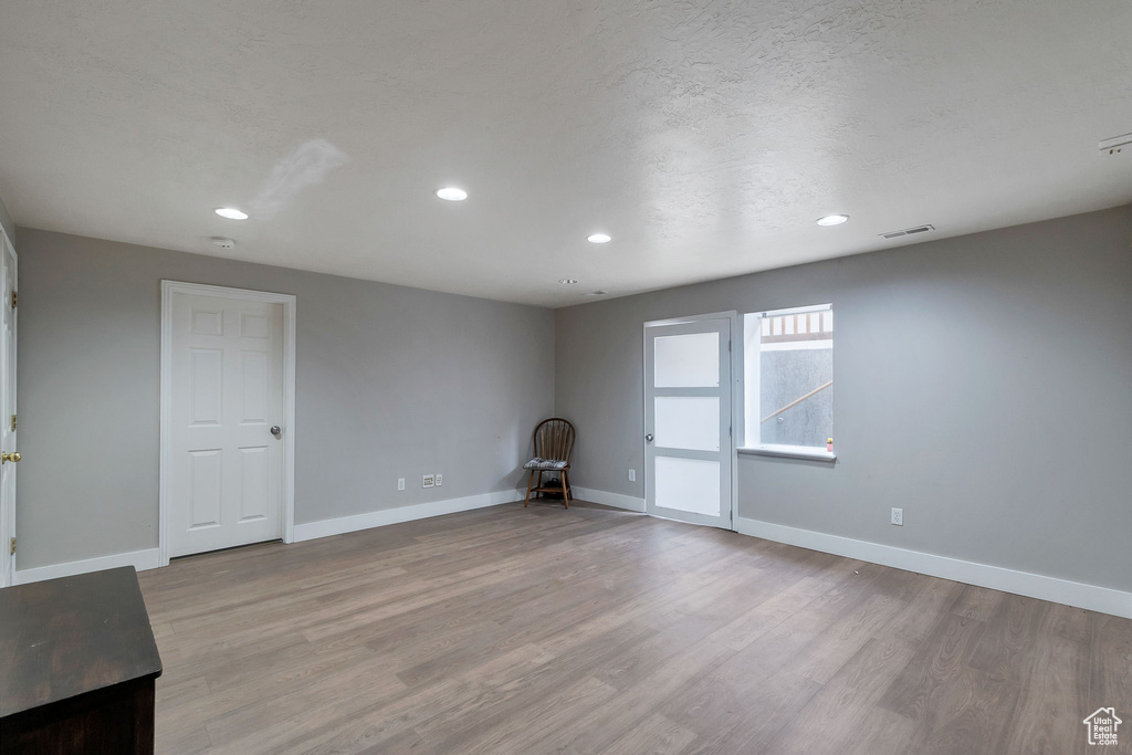 Empty room featuring recessed lighting, light wood-type flooring, and a textured ceiling