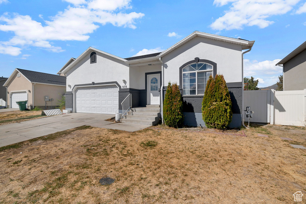 Ranch-style house with stucco siding, concrete driveway, and a garage