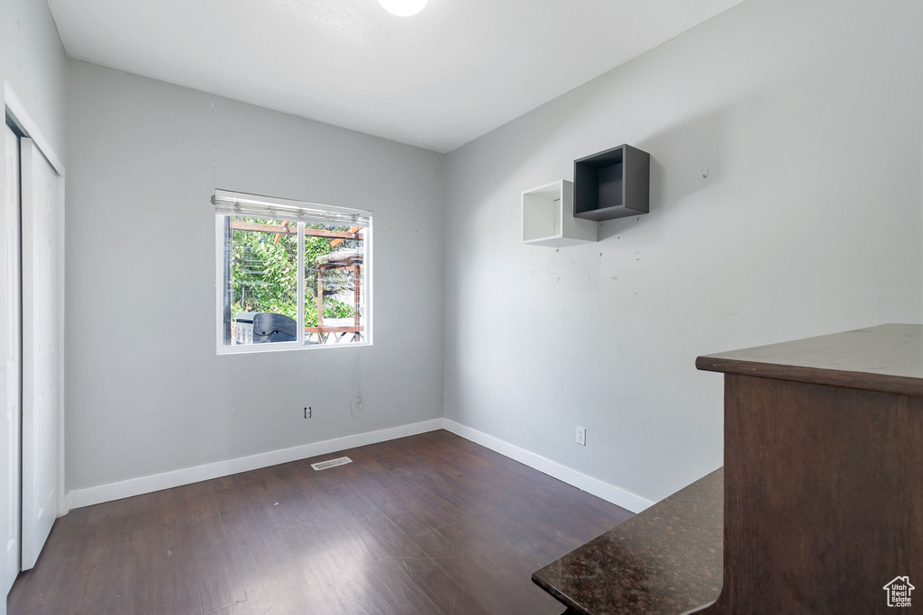 Unfurnished dining area with baseboards and dark wood finished floors