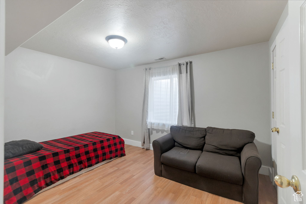 Bedroom featuring wood finished floors and a textured ceiling