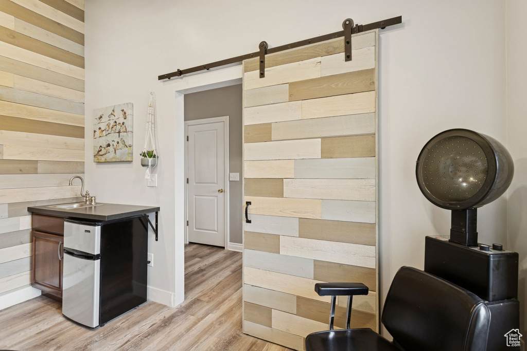 Kitchen featuring wood walls, light wood-type flooring, and a barn door