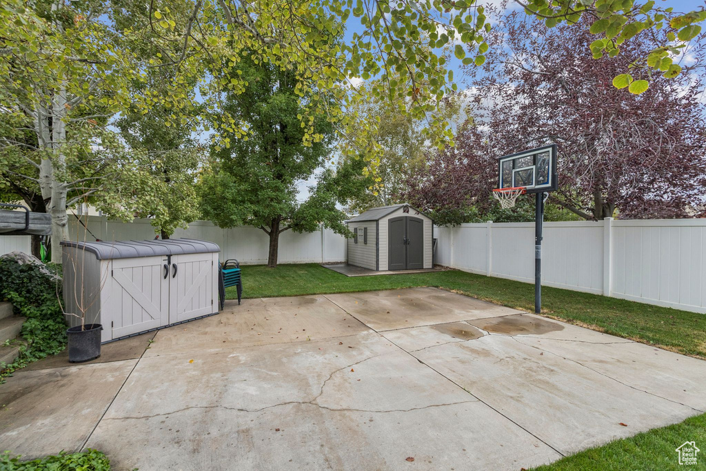 Fenced backyard featuring a shed and a patio