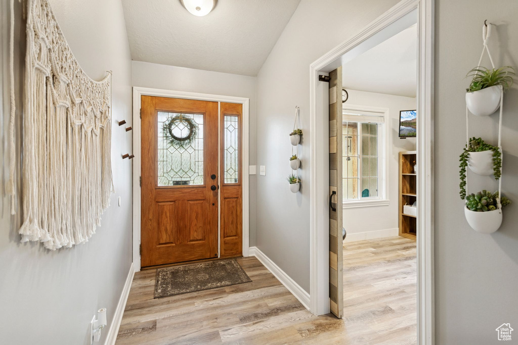 Foyer featuring light wood-style floors and baseboards