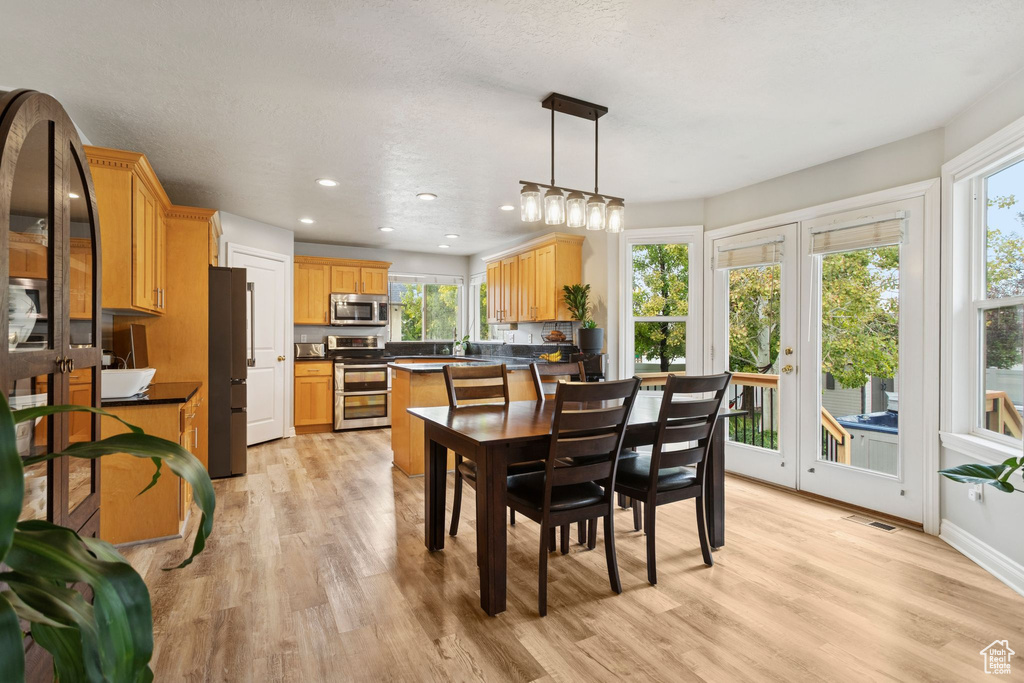 Dining area with light wood-style floors and recessed lighting