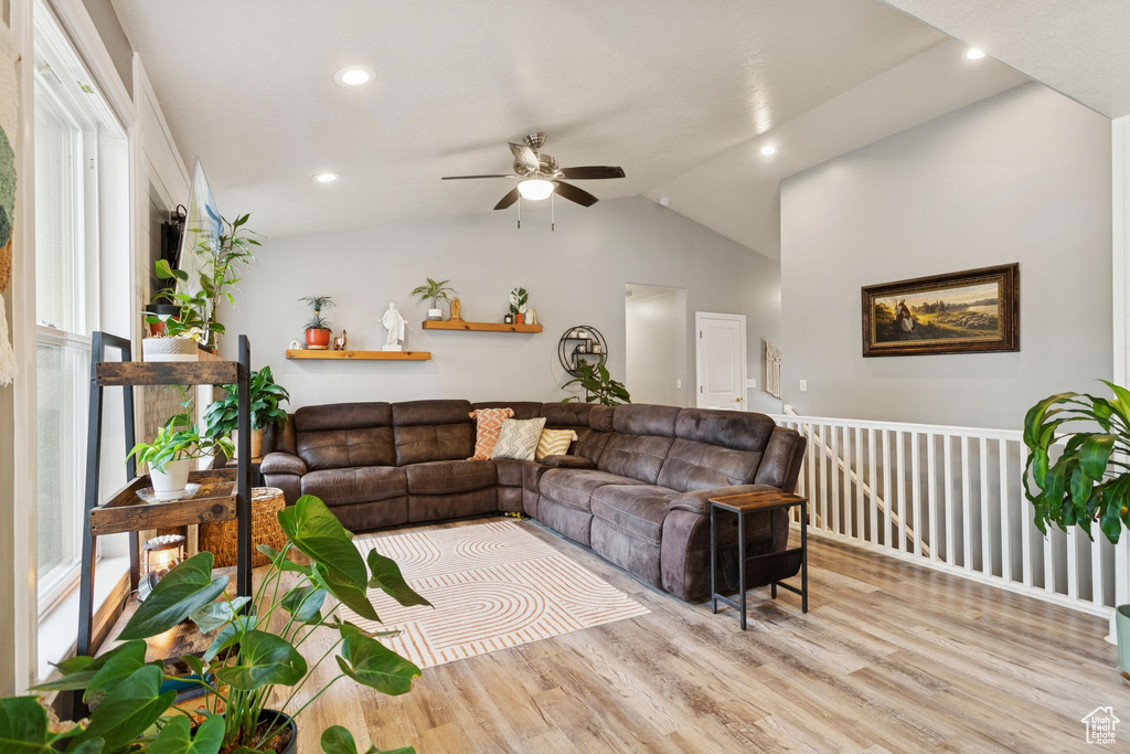 Living room with light wood-type flooring, lofted ceiling, ceiling fan, and recessed lighting