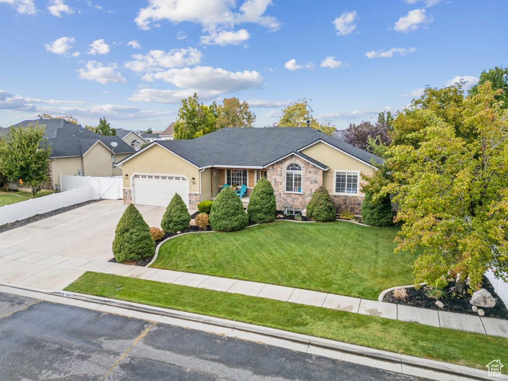 Single story home featuring stone siding, stucco siding, driveway, and a garage