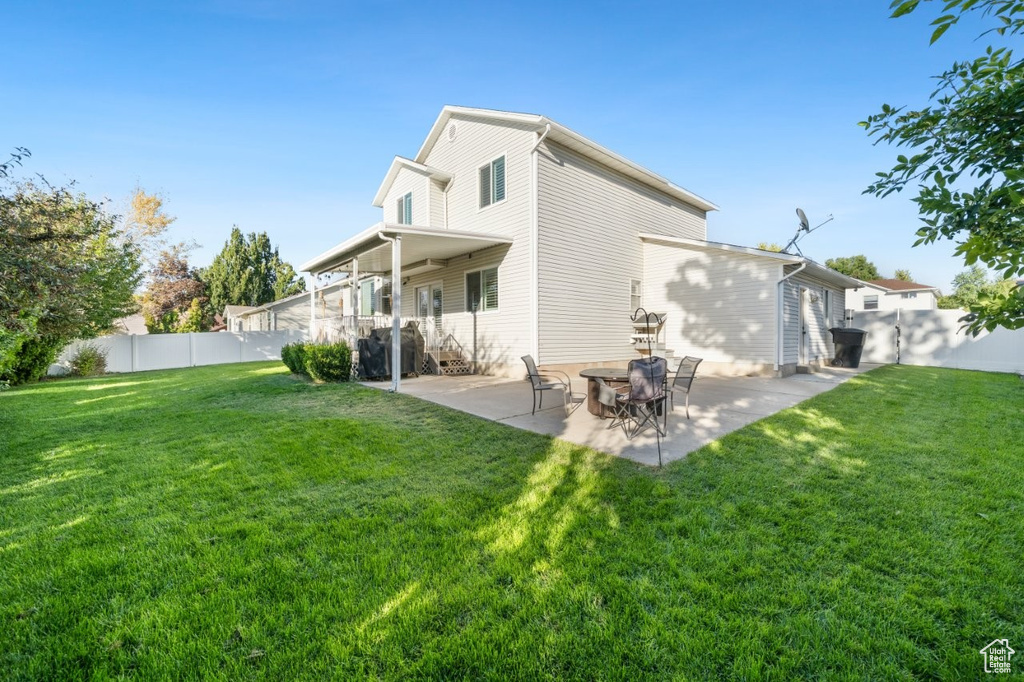 Rear view of house with a patio and a fenced backyard