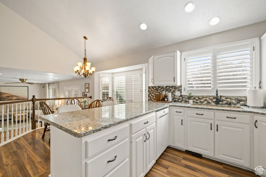 Kitchen featuring white cabinetry, light stone counters, recessed lighting, tasteful backsplash, and plenty of natural light